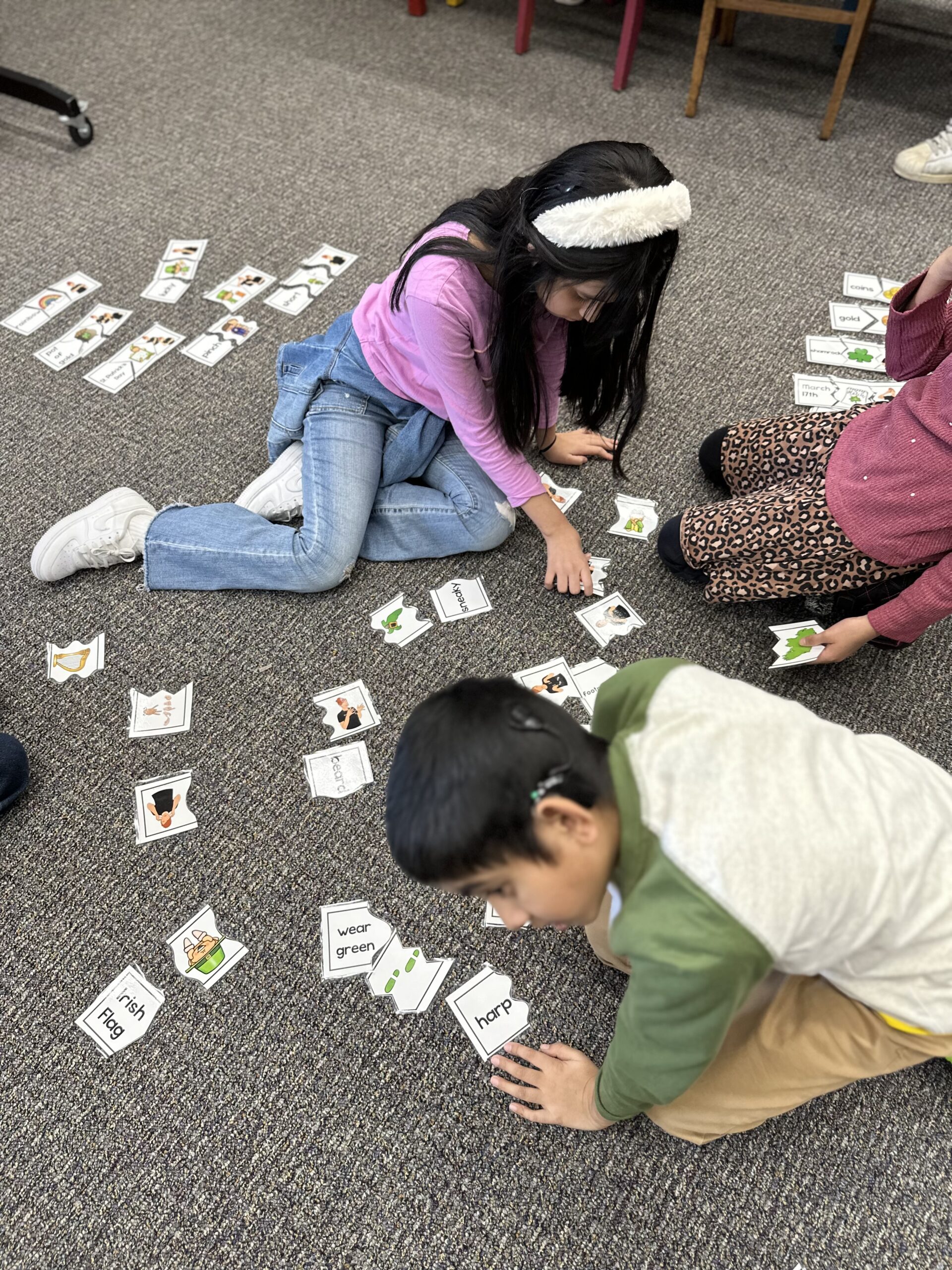 Students sit on the floor doing sight word work independently.