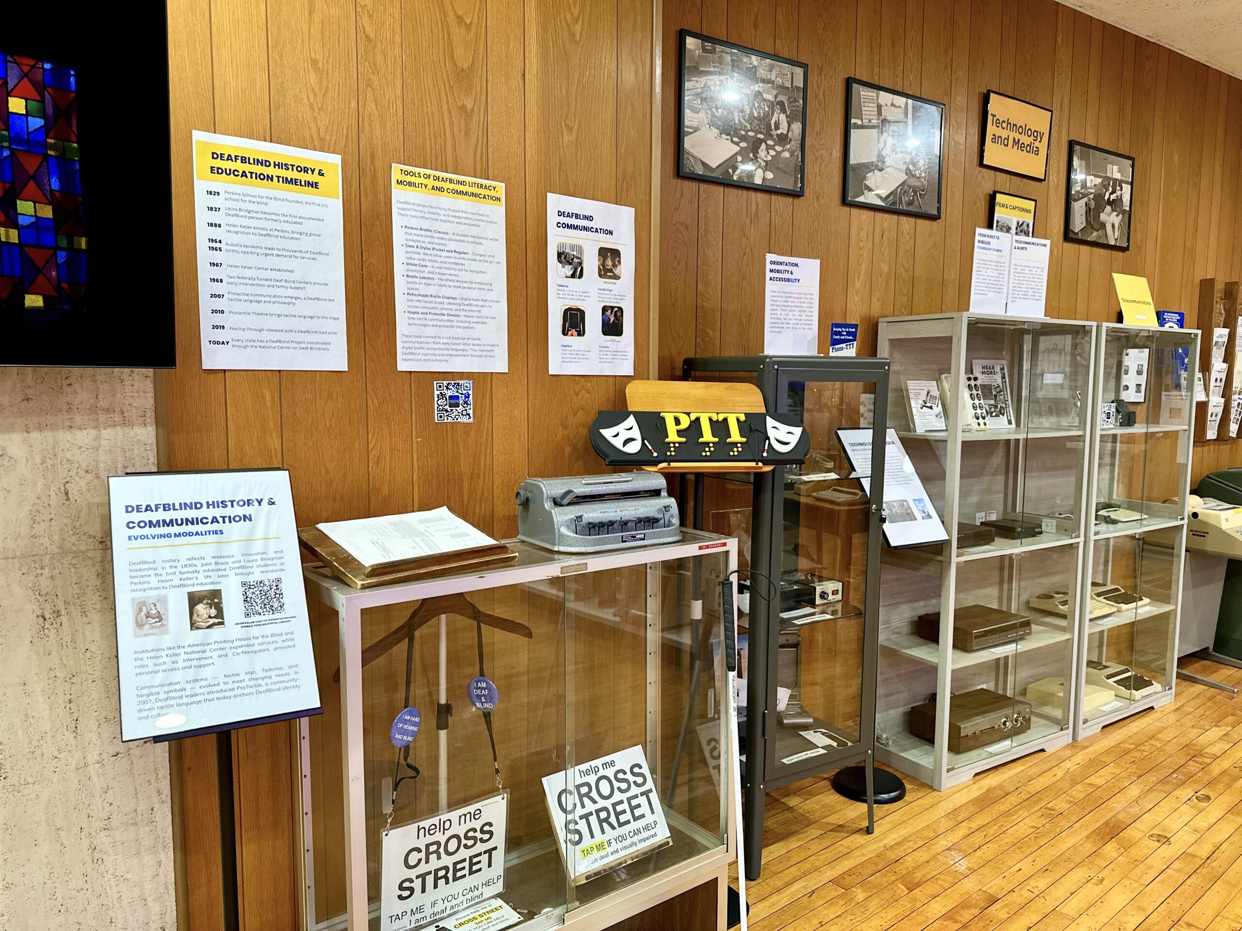 Museum display cases and framed exhibits documenting the history of the school and the Deaf community.