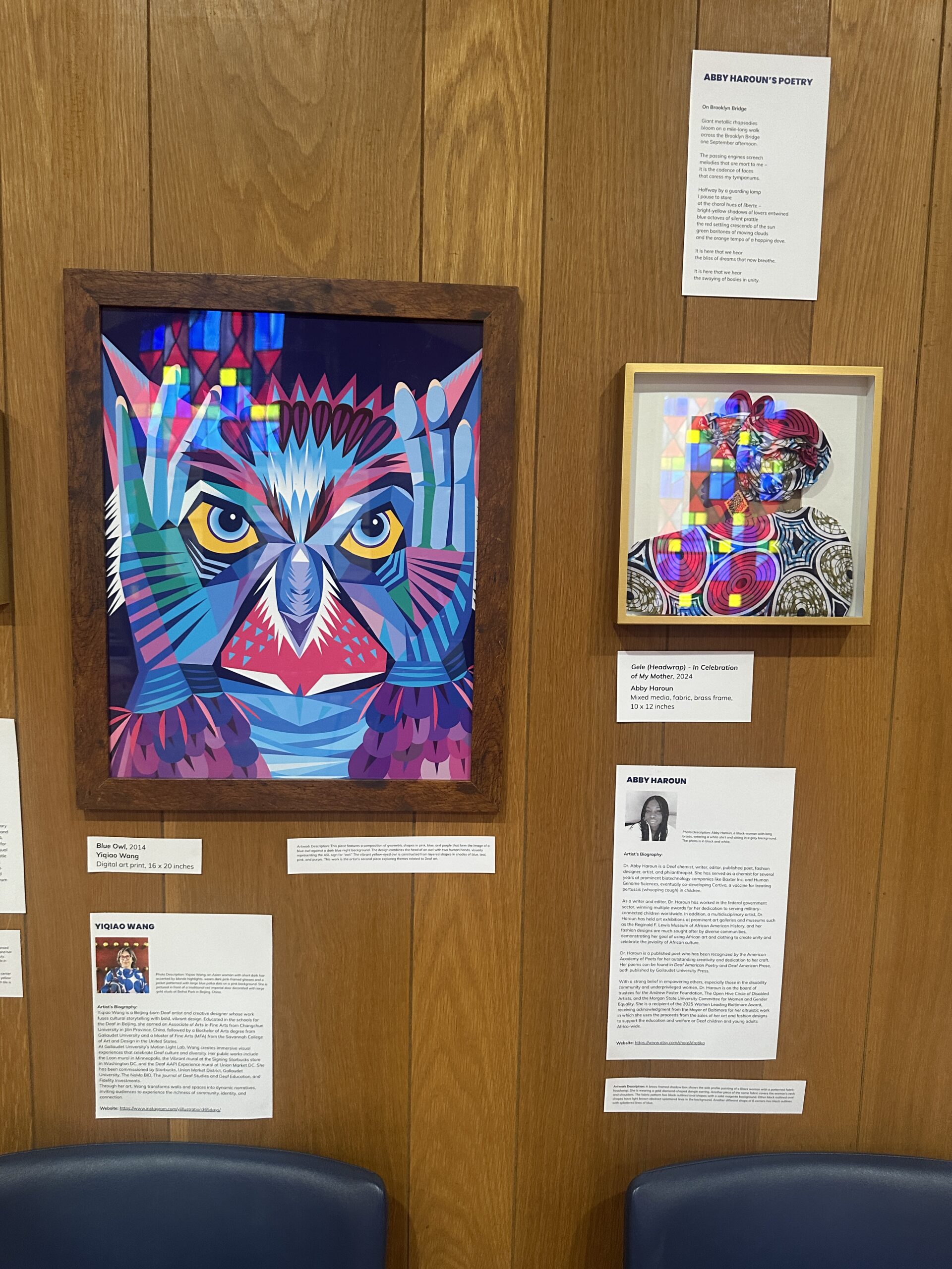 Framed artwork and documents displayed on the museum wall, including a brightly coloured painted portrait.