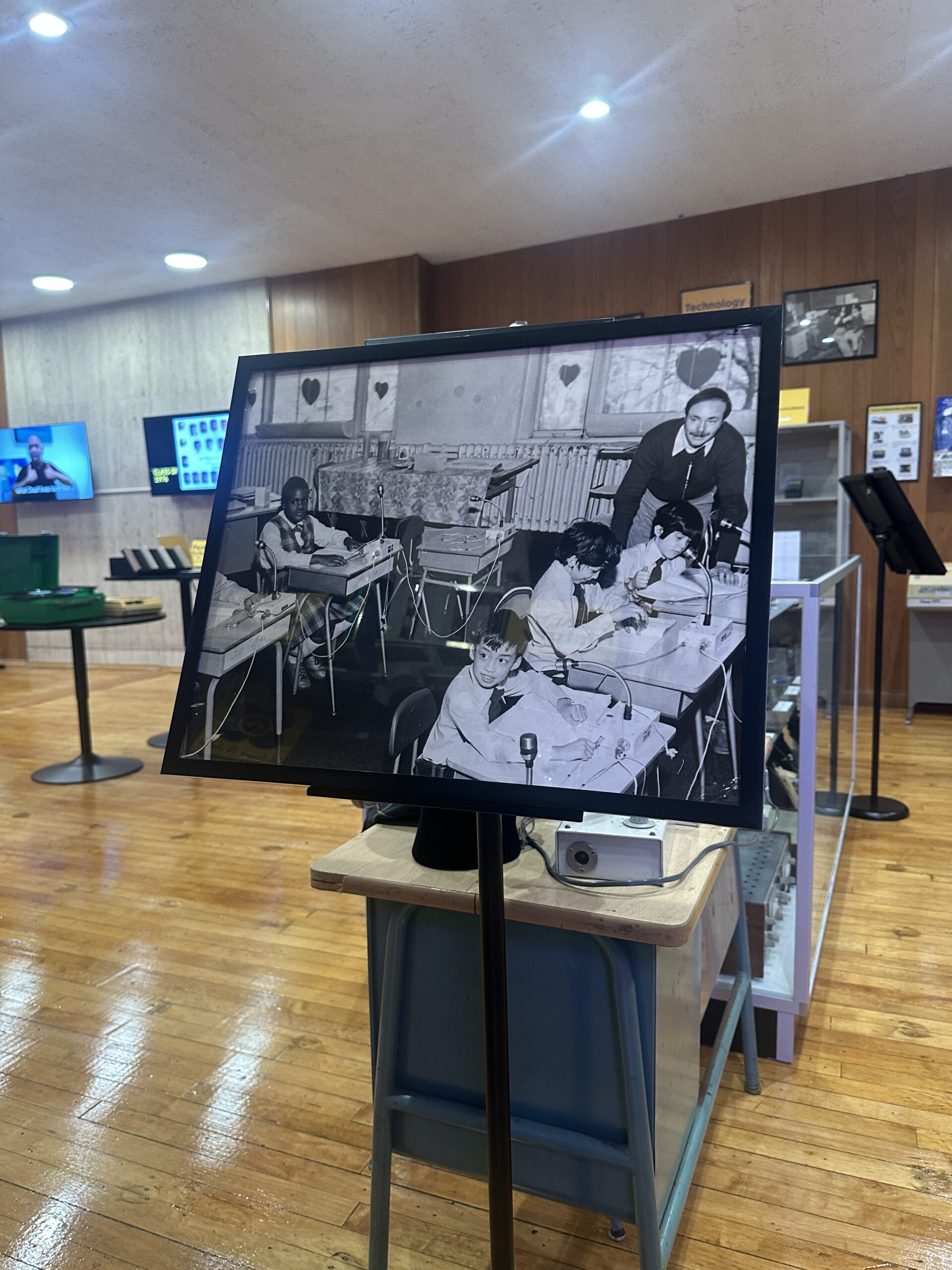A screen in the museum showing a historical black and white photograph of students at the school.
